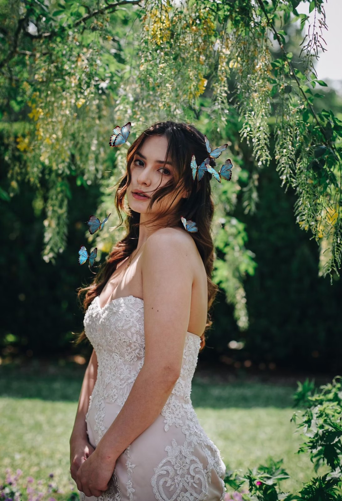 Bride with butterflies in her hair under a willow tree